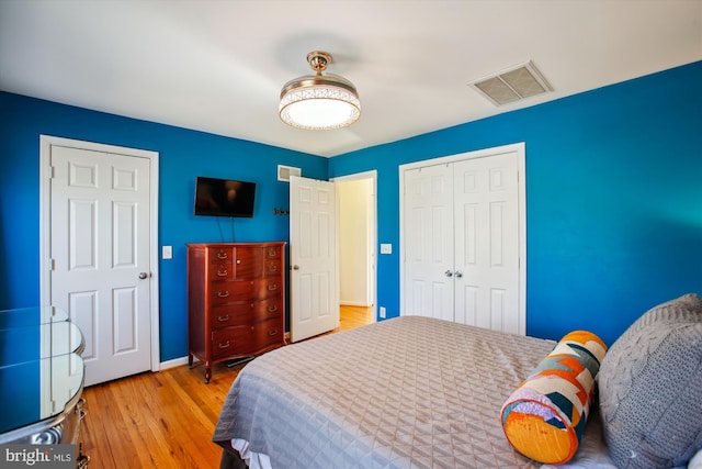 bedroom with light hardwood / wood-style floors and a closet