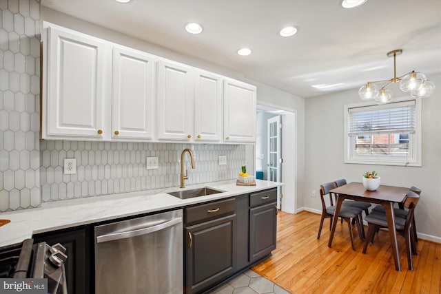 kitchen featuring appliances with stainless steel finishes, tasteful backsplash, white cabinetry, sink, and hanging light fixtures