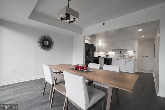 dining space with sink and dark wood-type flooring