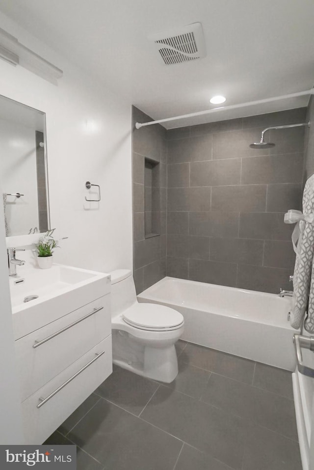 full bathroom featuring tile patterned floors, vanity, toilet, and tiled shower / bath combo