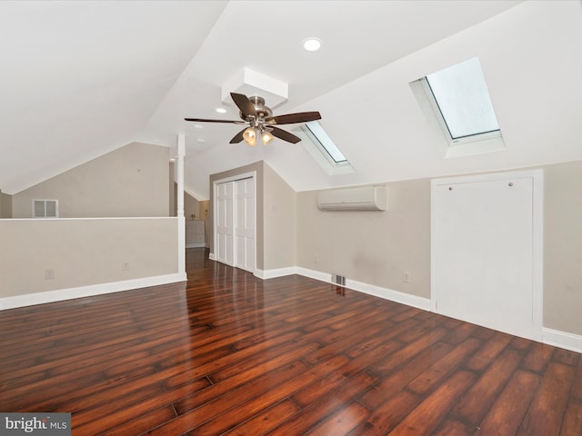 bonus room featuring vaulted ceiling with skylight, a wall mounted air conditioner, visible vents, and hardwood / wood-style floors