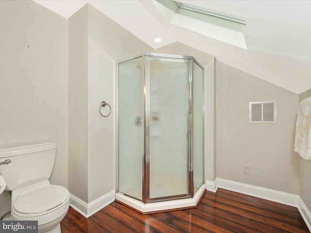 bathroom with a stall shower, baseboards, visible vents, wood finished floors, and vaulted ceiling