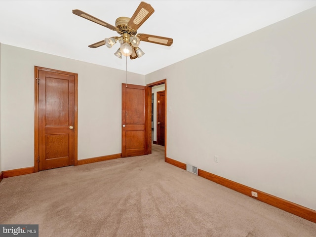 unfurnished bedroom with light carpet, visible vents, baseboards, and a ceiling fan