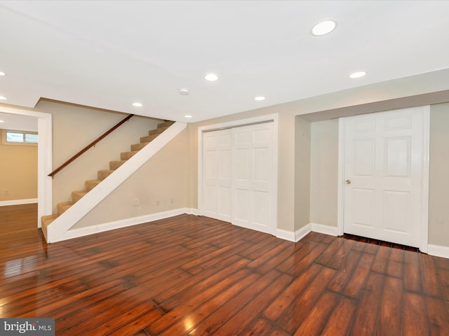 below grade area with stairs, baseboards, wood finished floors, and recessed lighting