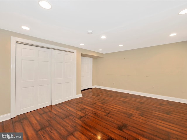 unfurnished bedroom with recessed lighting, a closet, baseboards, and wood finished floors