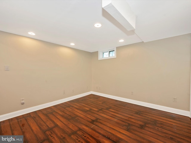 basement with baseboards, dark wood finished floors, and recessed lighting