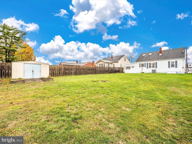 view of yard featuring an outbuilding, a shed, and a fenced backyard