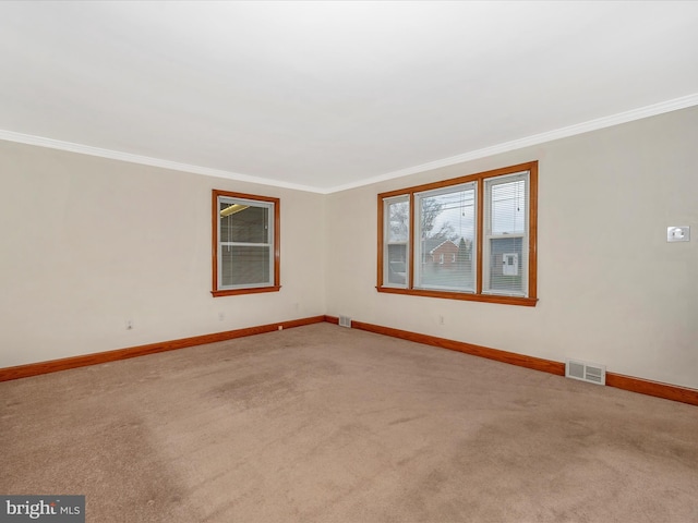 unfurnished room with ornamental molding, carpet flooring, visible vents, and baseboards