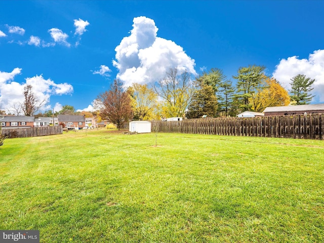 view of yard with a storage shed, fence, and an outdoor structure