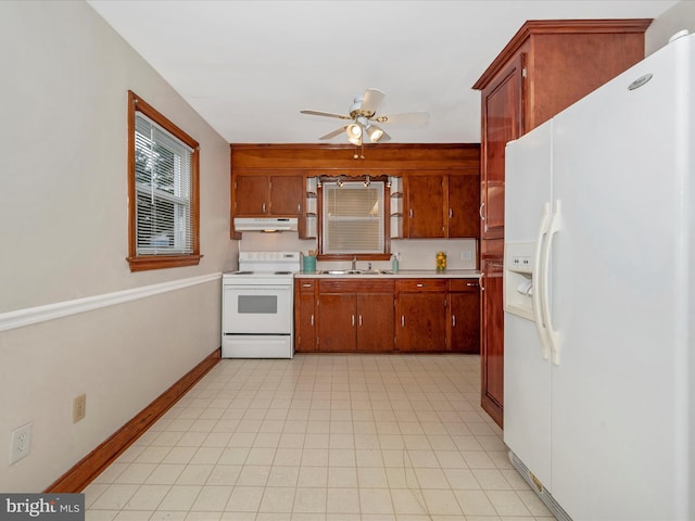 kitchen with light countertops, a ceiling fan, a sink, white appliances, and under cabinet range hood