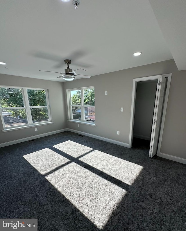 unfurnished room with dark carpet