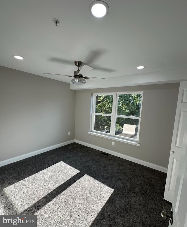 carpeted spare room with ceiling fan