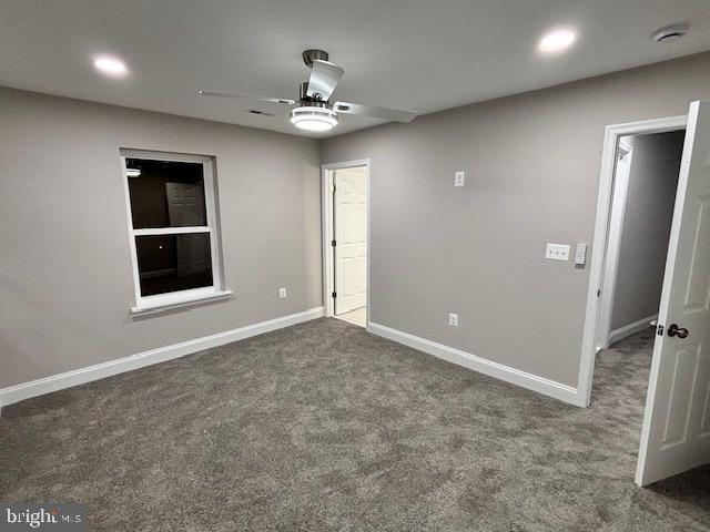 carpeted spare room with ceiling fan