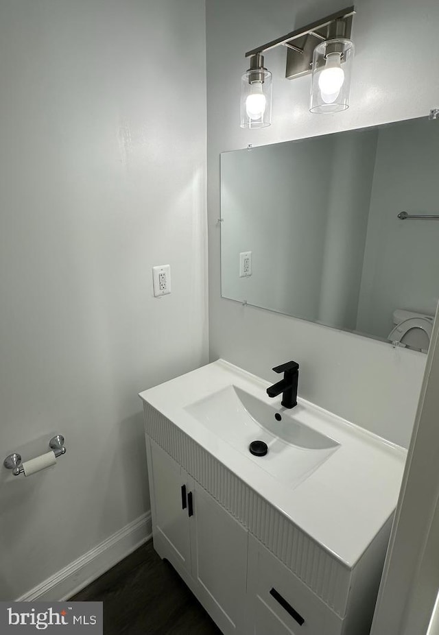 bathroom with vanity, hardwood / wood-style floors, and toilet