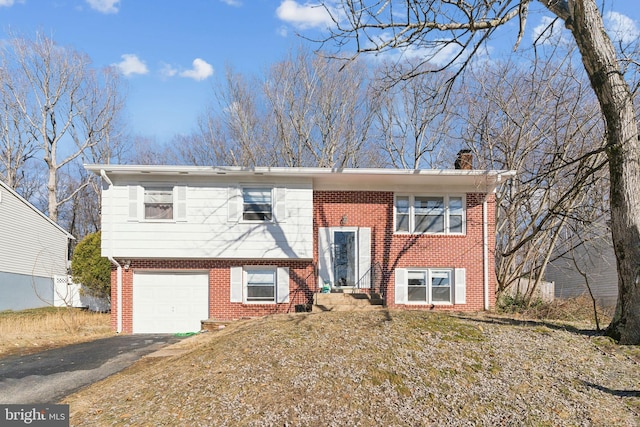 bi-level home with a garage and a front yard