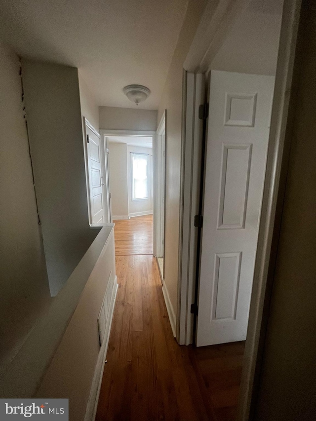 corridor with hardwood / wood-style flooring