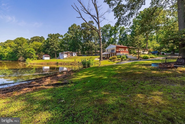 view of yard featuring a storage shed and a water view