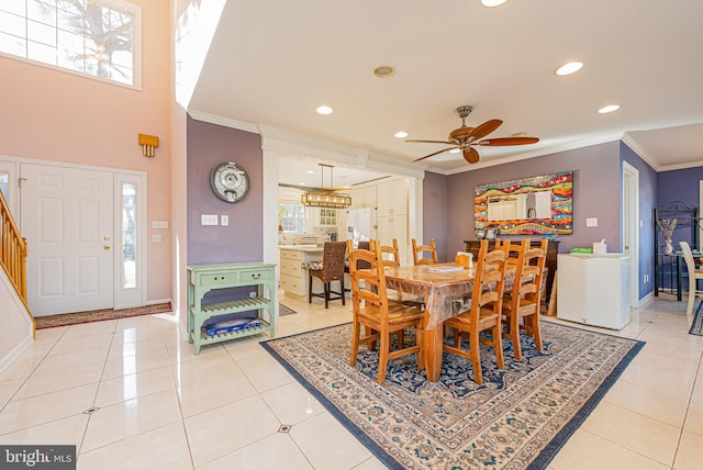 dining space featuring tile patterned flooring, ornamental molding, and ceiling fan