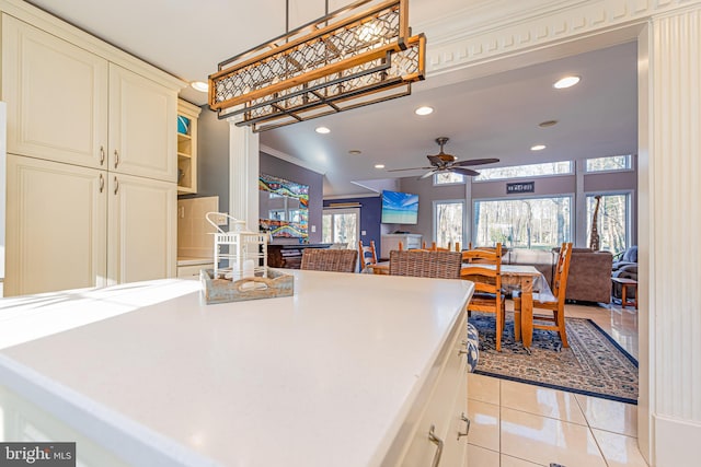 kitchen with crown molding, ceiling fan, hanging light fixtures, and light tile patterned floors