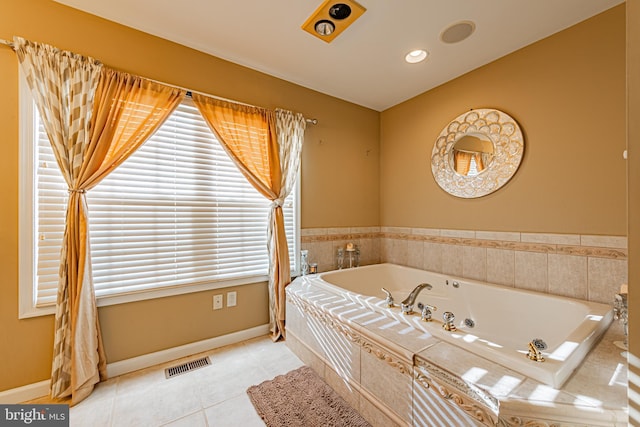 bathroom with tile patterned flooring, tiled tub, and lofted ceiling