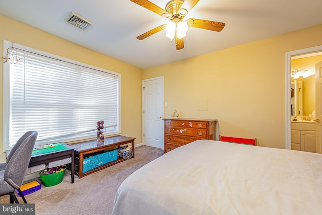 carpeted bedroom featuring ensuite bath and ceiling fan