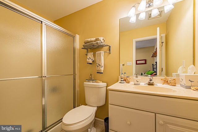 bathroom with vanity, a shower with door, and toilet