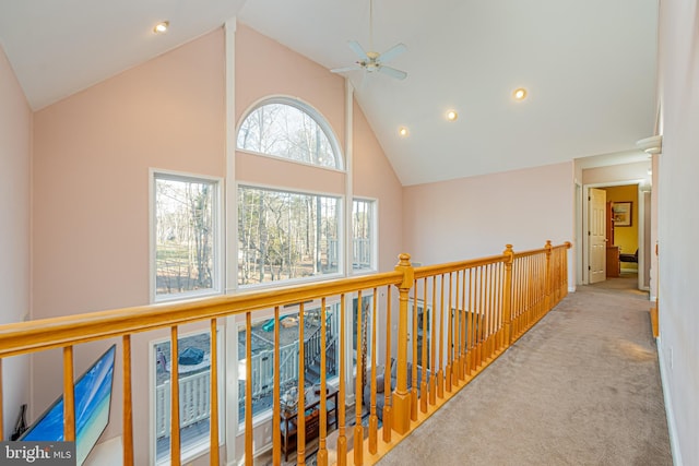 hall with high vaulted ceiling and light colored carpet