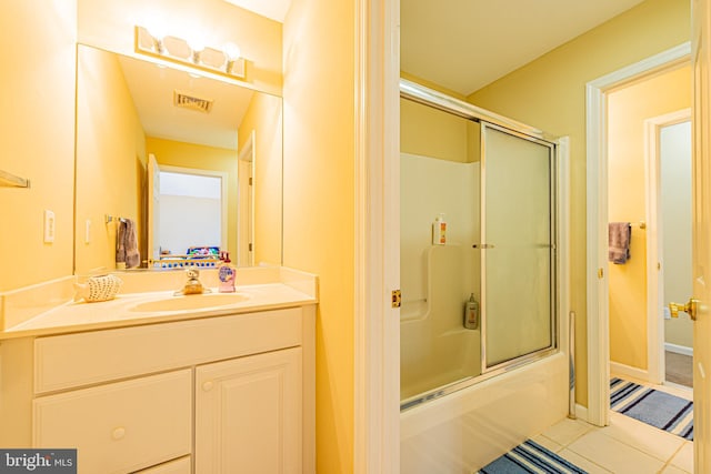 bathroom with tile patterned flooring, vanity, and shower / bath combination with glass door