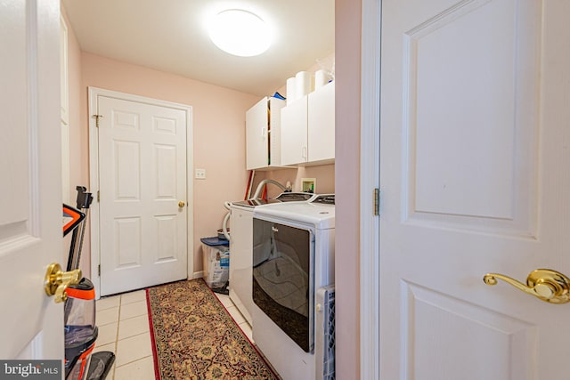 clothes washing area with cabinets, light tile patterned floors, and independent washer and dryer