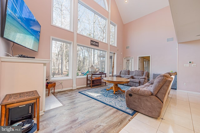 living room with plenty of natural light, vaulted ceiling, and light wood-type flooring