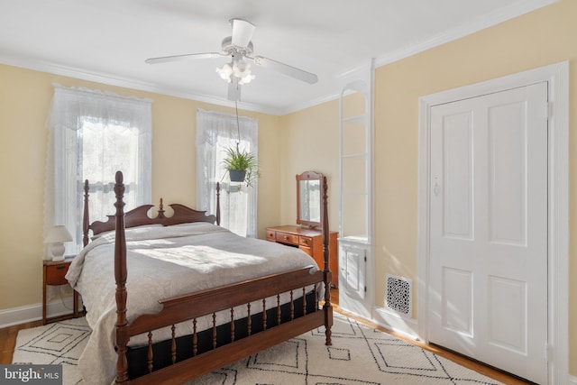 bedroom featuring visible vents, baseboards, a ceiling fan, crown molding, and light wood-type flooring