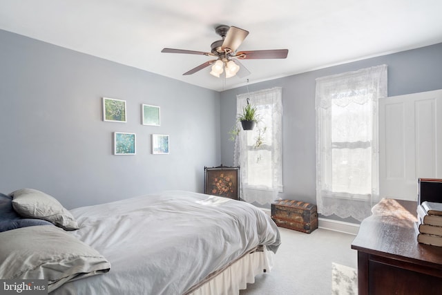 bedroom featuring light colored carpet, ceiling fan, and baseboards