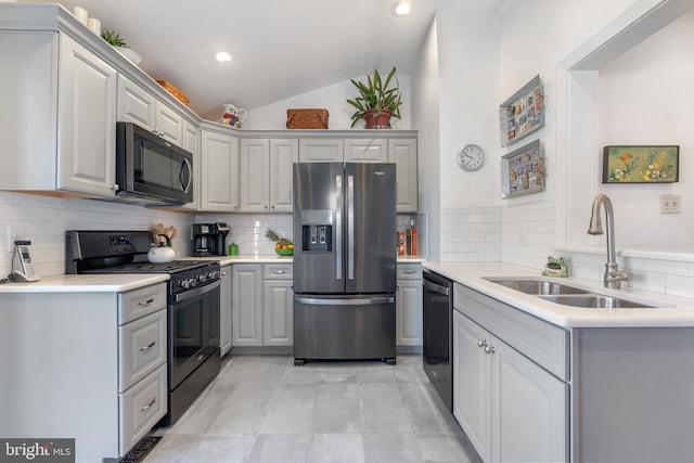 kitchen with stainless steel appliances, light countertops, a sink, and gray cabinetry