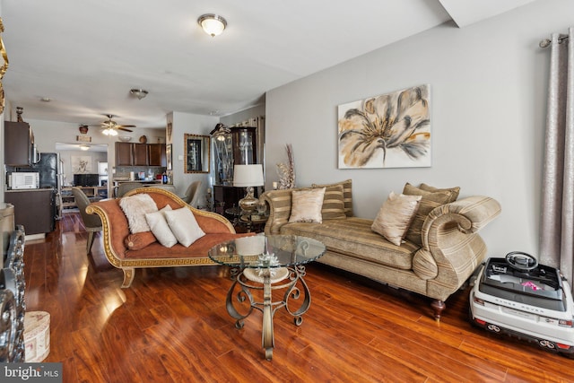 living room featuring hardwood / wood-style floors and ceiling fan