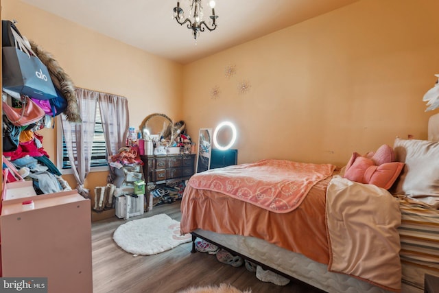 bedroom with hardwood / wood-style flooring and a notable chandelier