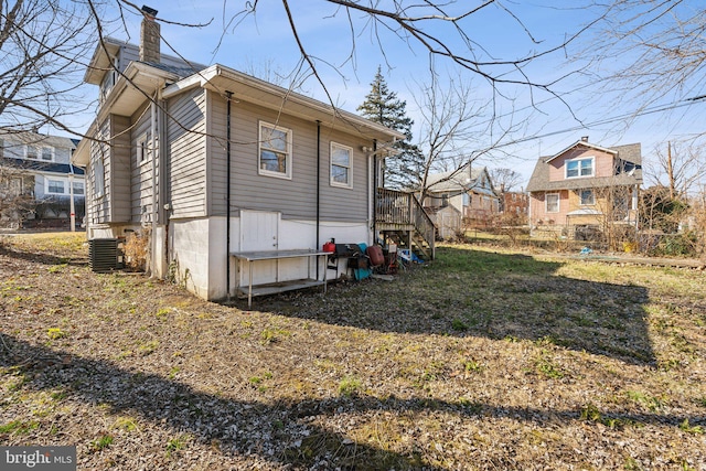 view of property exterior with a lawn and central AC