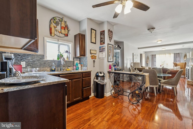 kitchen featuring dark hardwood / wood-style flooring, sink, dark brown cabinets, and backsplash