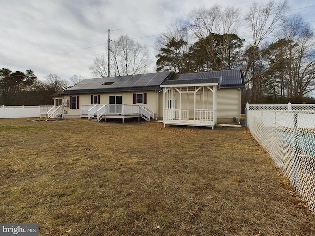 23338 Park Ave, Georgetown, DE 19947 - back of house featuring a lawn, solar panels, and a deck