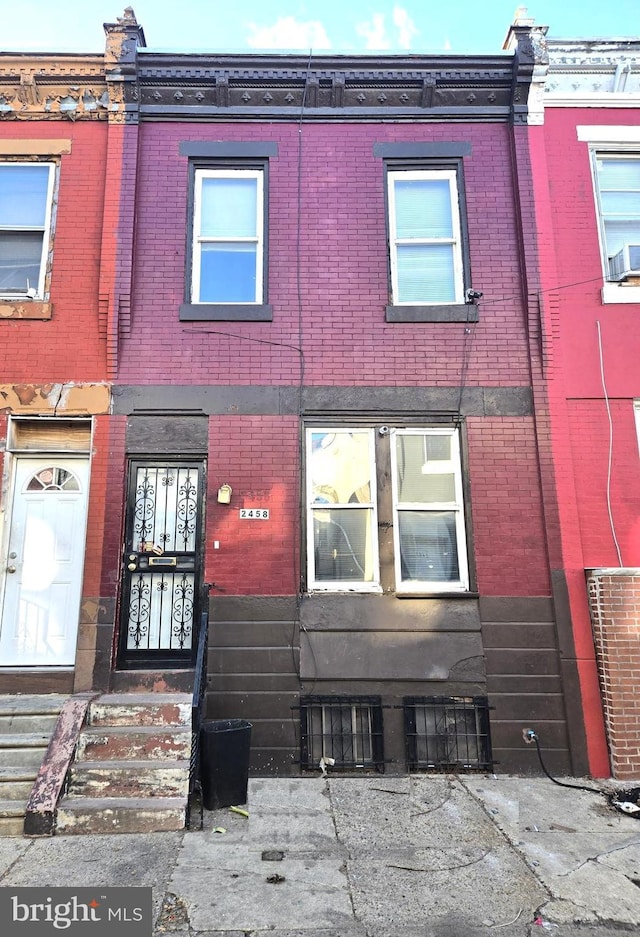 view of property with entry steps and brick siding