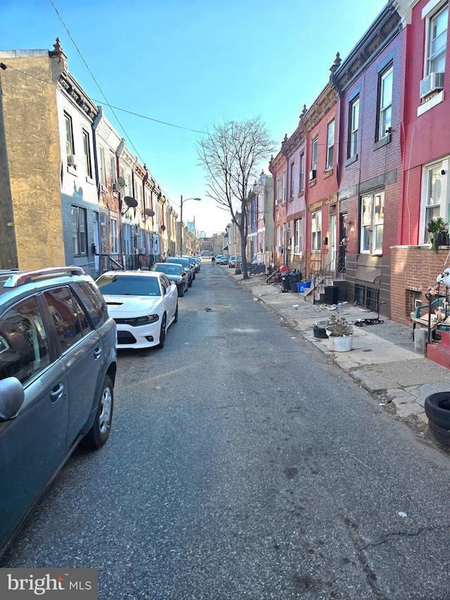 view of road featuring street lighting, a residential view, and sidewalks