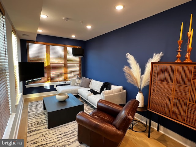 living room featuring baseboards, wood finished floors, and recessed lighting