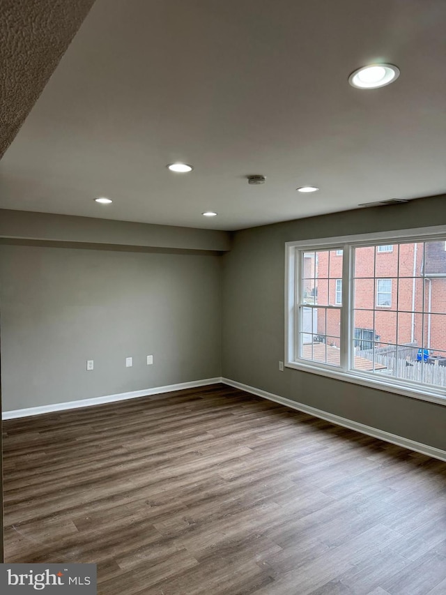 empty room featuring wood-type flooring and plenty of natural light