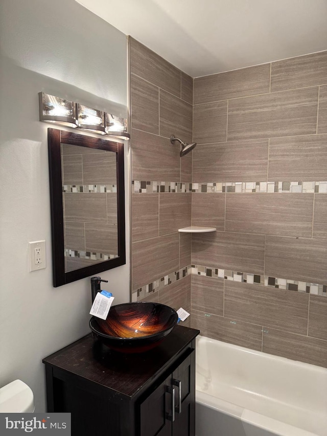 full bathroom featuring vanity, toilet, and tiled shower / bath