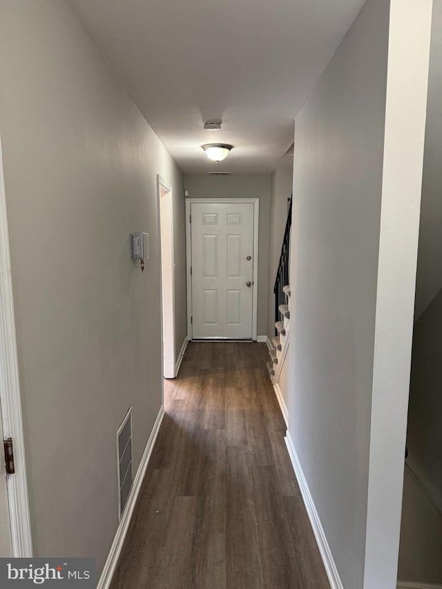 hallway with dark hardwood / wood-style flooring