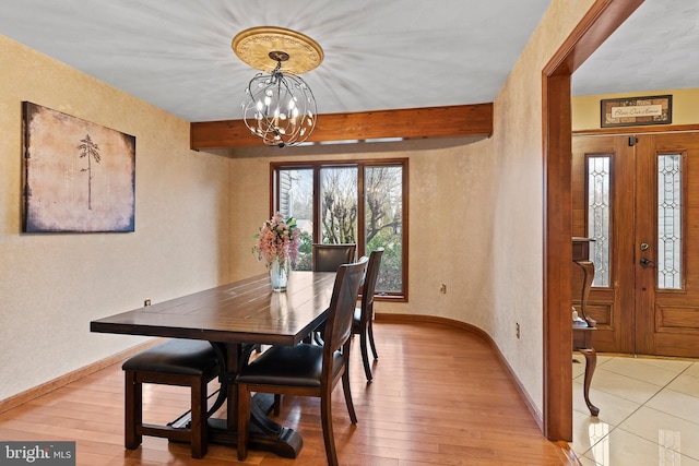 dining room featuring a notable chandelier, beamed ceiling, and light hardwood / wood-style flooring