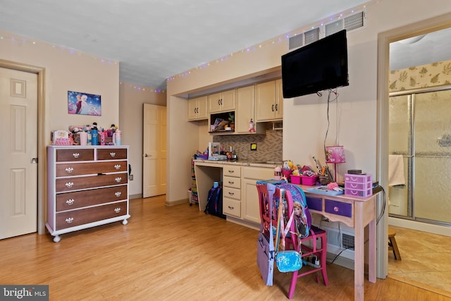 kitchen featuring light hardwood / wood-style floors and backsplash