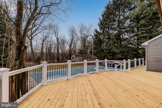 deck featuring a covered pool and a storage shed