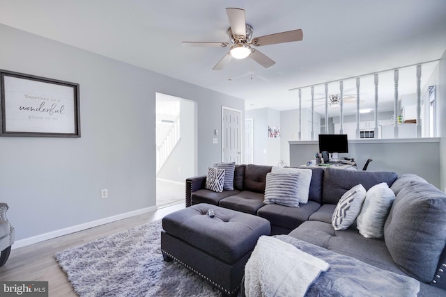 living room featuring hardwood / wood-style floors and ceiling fan