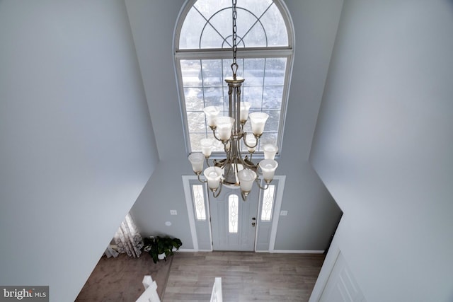 foyer entrance featuring wood-type flooring and an inviting chandelier