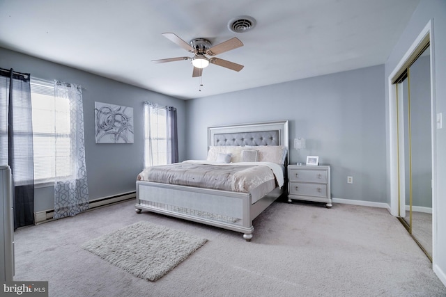 carpeted bedroom with a baseboard radiator, a closet, and ceiling fan